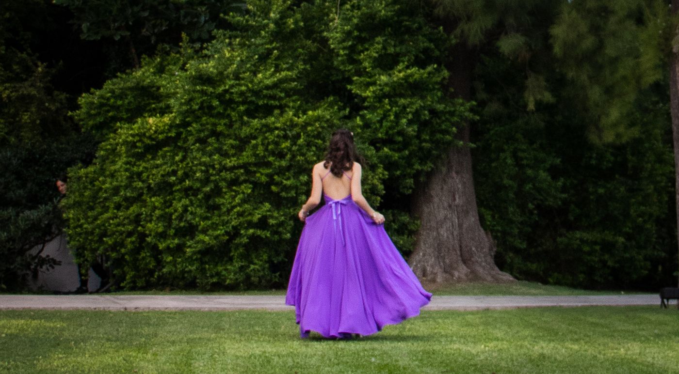 Quinceañera con vestido violeta girando al aire libre en Rosario — Proyecto Confite